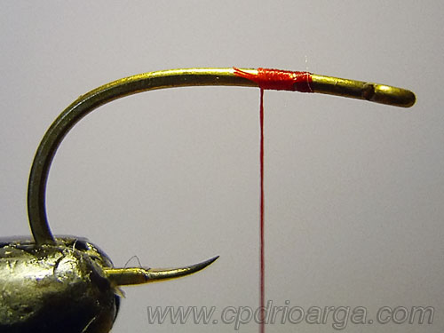 Colocamos el anzuelo en el torno sujetando el hilo de montaje sanjuan1