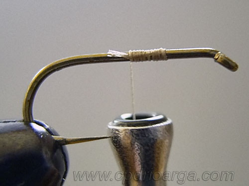 Colocamos el anzuelo y sujetamos el hilo de montaje trico2